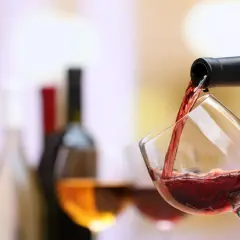 Un verre de pinot noir se remplit, prêt à accompagner un plat savoureux.