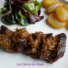 Un onglet à l'échalote, servi avec une salade verte et des pommes de terre sautées. Un plat savoureux et coloré.