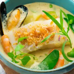 Une délicieuse marmite du pêcheur crémeuse avec poisson blanc, crevettes, moules, petits pois et herbes fraîches.