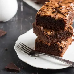 Pile de gâteaux au chocolat sur une assiette blanche avec une fourchette.