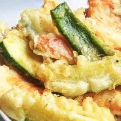 Un assortiment coloré de tempura de légumes, avec des courgettes, des haricots verts et d'autres délices croustillants.