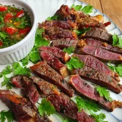 Tranches de bœuf grillé, juteuses et saignantes, servies avec une sauce tomate et coriandre. Un plat qui ferait presque pleurer de joie un tigre gourmand.