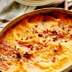 Hachis Parmentier gratiné, doré et parsemé de noix dans un plat ovale.