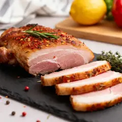 Un rôti de porc juteux, tranché, assaisonné d'épices et de romarin. Une recette de pluma de porc à essayer !