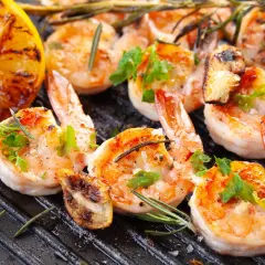 Crevettes grillées sur plancha, citron rôti et herbes fraîches. Une recette plancha conviviale parfaite pour partager.