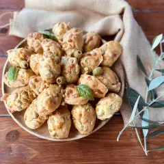 Plate of savory madeleines with olives and basil, perfect for an aperitif.