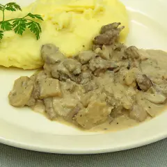 Rognons de porc en sauce crémeuse avec des champignons, servis avec une purée de pommes de terre onctueuse. Parfait pour savoir avec quoi accompagner des rognons de porc.