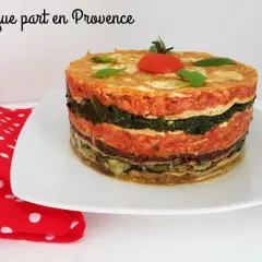 Un délicieux gâteau d'omelette provençale, aux couches colorées de légumes et de sauce tomate, garni d'une tomate cerise.