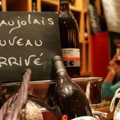 Le Beaujolais Nouveau est arrivé ! Une femme déguste ce vin jeune, symbole de la conservation des traditions viticoles.
