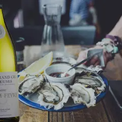 Bouteille de Chablis Grand Cru William Fèvre à côté d'huîtres fraîches. Le parfait accord pour savoir quel vin avec les huîtres.