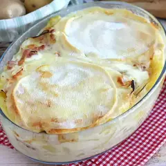 Un plat de tartiflette traditionnelle gratinée, avec son fromage fondant et ses lardons, prêt à être dégusté.
