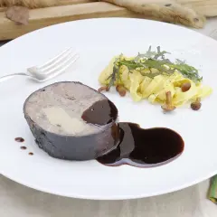 Un rôti de lièvre à la royale, garni de foie gras, servi avec des pâtes fraîches, des champignons et une sauce au vin.