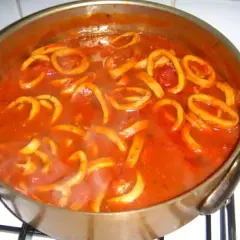 Calamars à l'armoricaine mijotant dans une sauce tomate savoureuse. Un plat réconfortant prêt à être dégusté.