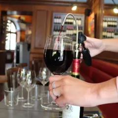 Service d'un vin rouge ouvert avec un tire-bouchon à pompe. La conservation du vin est assurée.