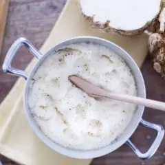 Un crémeux **purée de céleri** dans une casserole, avec du céleri-rave, du parmesan et du poivre.