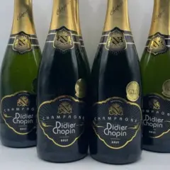 Quatre bouteilles de champagne Didier Chopin Brut, deux en verre sombre et deux en verre vert, avec leurs étiquettes noires et dorées. Un avis sur champagne Didier Chopin.