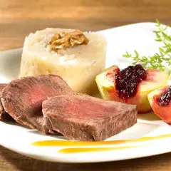 Tranches de fondue de biche, purée de céleri-rave à la noix, quartiers de pêche poêlée au coulis de fruits rouges.
