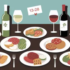 Table dressée avec lapin blanc, assiettes de mets et bouteilles de vin. Quel vin avec du lapin ? Le rouge semble être un bon choix.
