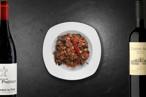 Un plat de chili con carne épicé, accompagné de deux bouteilles de vin rouge. Quel vin avec chili con carne ?