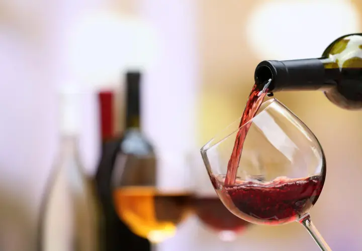 Un verre de pinot noir se remplit, prêt à accompagner un plat savoureux.
