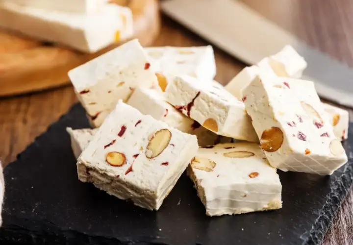 Délicieux nougat blanc aux amandes et fruits secs, parfait pour une recette maison.