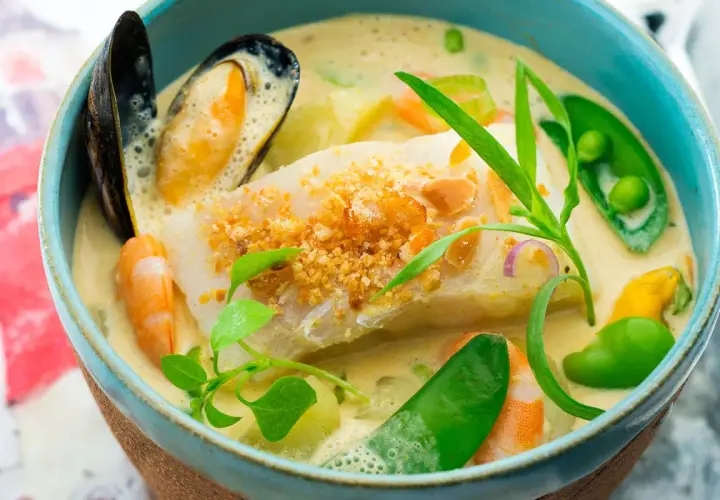 Une délicieuse marmite du pêcheur crémeuse avec poisson blanc, crevettes, moules, petits pois et herbes fraîches.