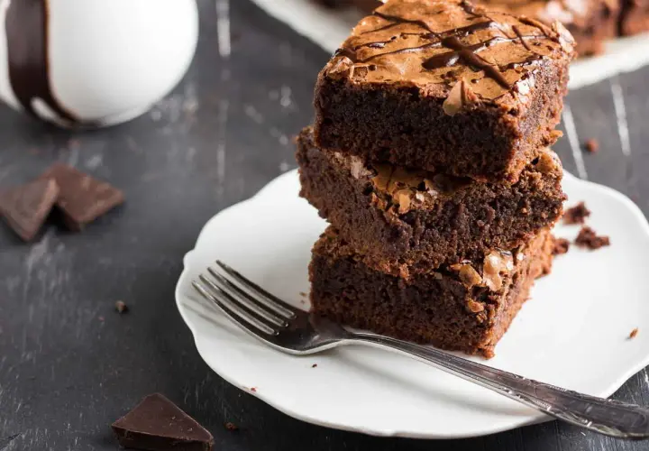 Pile de gâteaux au chocolat sur une assiette blanche avec une fourchette.
