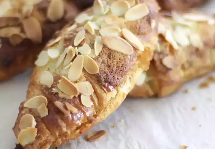 Croissants aux amandes dorés et croustillants, parsemés d'amandes effilées.