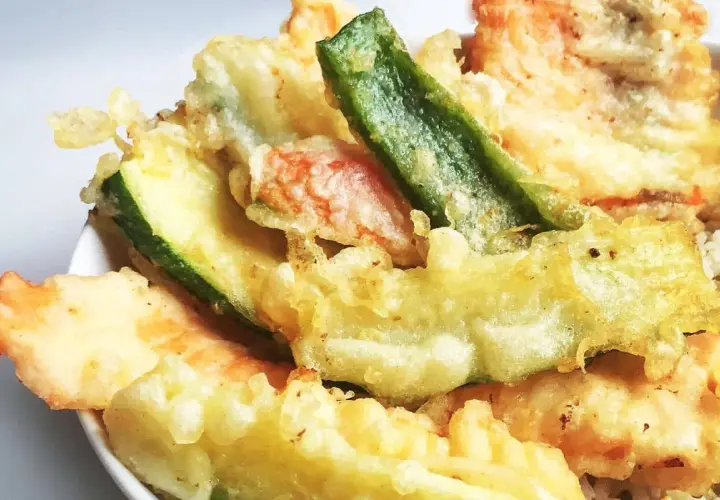 Un assortiment coloré de tempura de légumes, avec des courgettes, des haricots verts et d'autres délices croustillants.