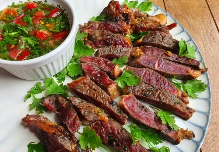 Tranches de bœuf grillé, juteuses et saignantes, servies avec une sauce tomate et coriandre. Un plat qui ferait presque pleurer de joie un tigre gourmand.
