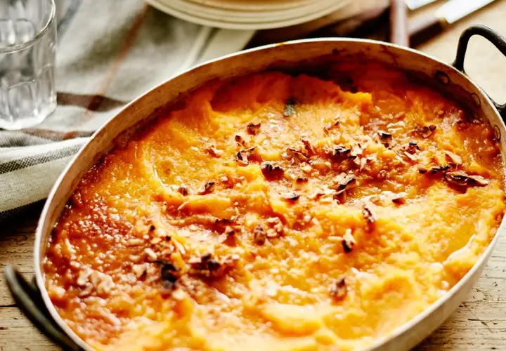 Hachis Parmentier gratiné, doré et parsemé de noix dans un plat ovale.