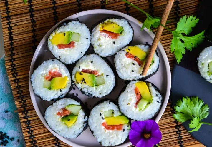 Assiette de makis frais, remplis d'avocat, concombre et saumon. Une belle recette sushi pour un repas léger.