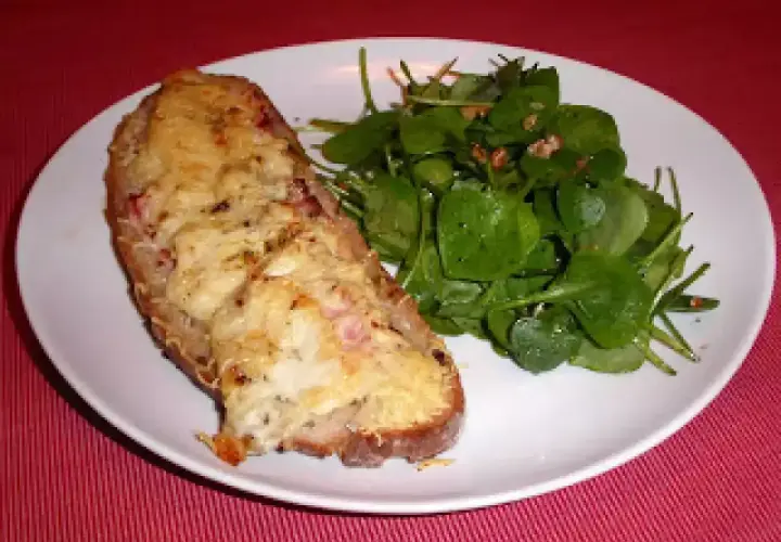 Tartine campagnarde au four, gratinée et dorée, servie avec une salade verte fraîche. Un délice simple et savoureux.