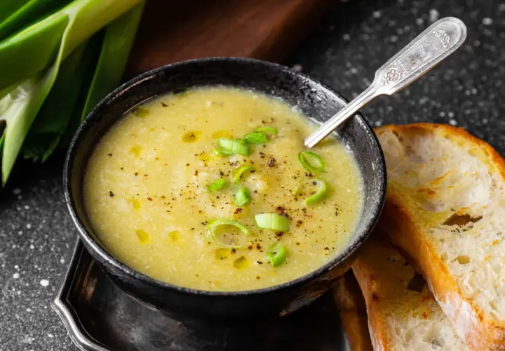 Un réconfortant velouté de poireaux pommes de terre, garni de ciboule et servi avec du pain grillé.