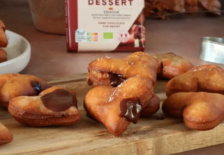 Des cœurs gourmands de beignet au chocolat, certains saupoudrés de sucre, d'autres généreusement garnis de chocolat fondant.