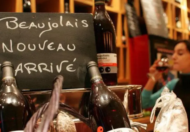 Le Beaujolais Nouveau est arrivé ! Une femme déguste ce vin jeune, symbole de la conservation des traditions viticoles.