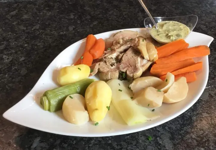 Tête de veau savoureuse accompagnée de carottes, pommes de terre et poireaux, le tout nappé d'une sauce crémeuse.