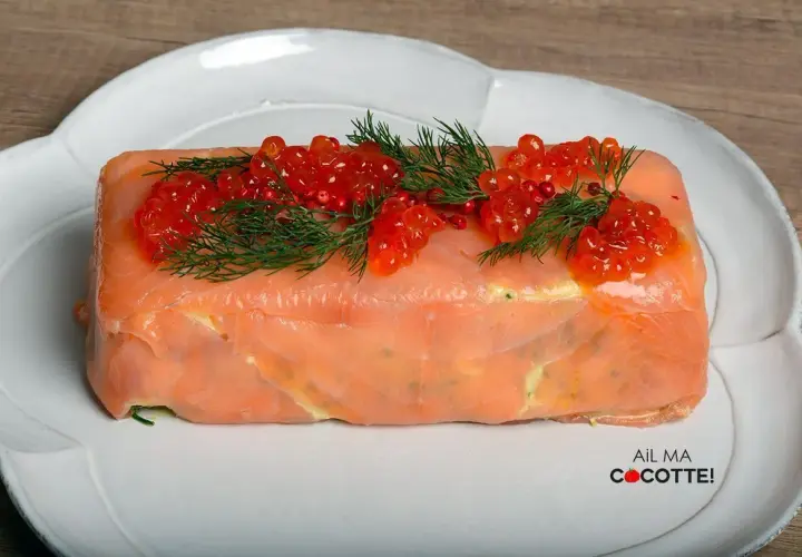 Terrine de saumon chef étoilé, ornée de perles de corail et d'aneth, une création culinaire raffinée.