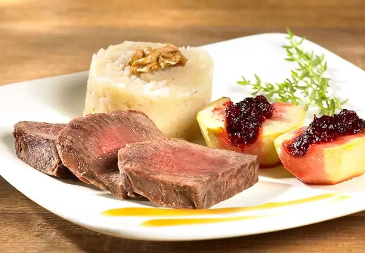 Tranches de fondue de biche, purée de céleri-rave à la noix, quartiers de pêche poêlée au coulis de fruits rouges.