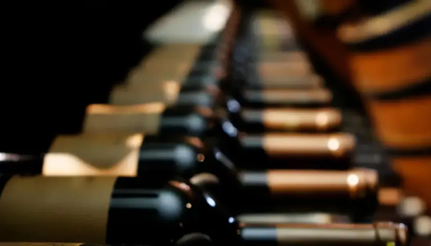 Des bouteilles de vin de garde alignées dans une cave sombre, attendant patiemment de révéler leurs arômes complexes.