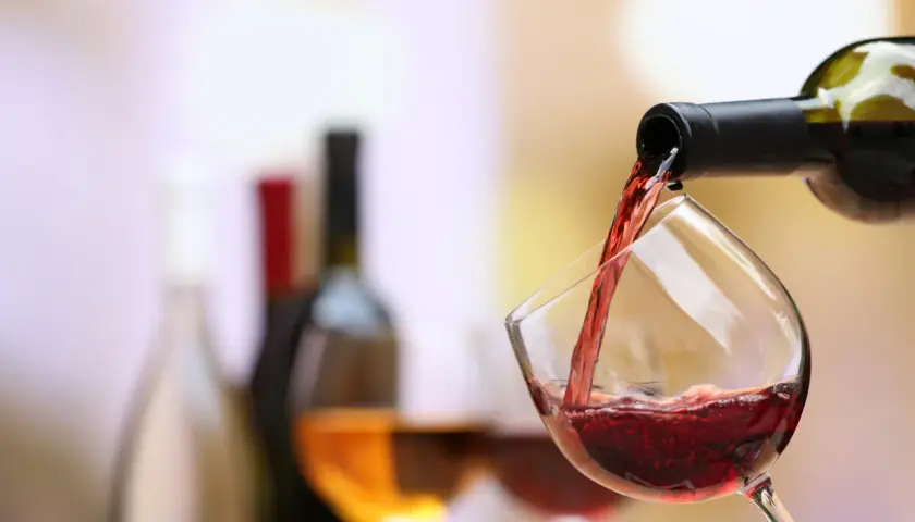 Un verre de pinot noir se remplit, prêt à accompagner un plat savoureux.