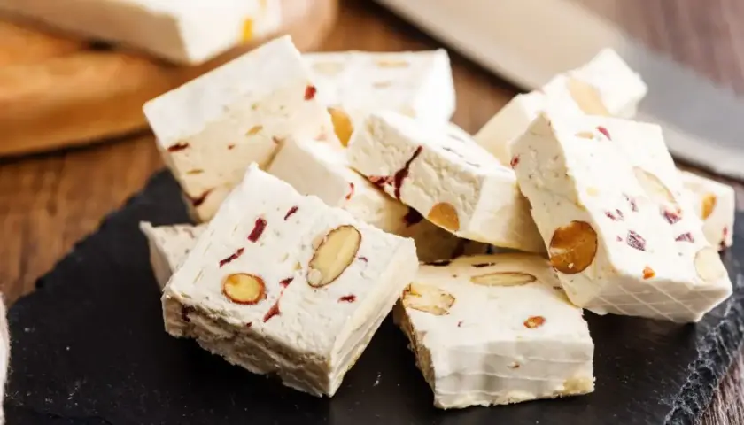 Délicieux nougat blanc aux amandes et fruits secs, parfait pour une recette maison.