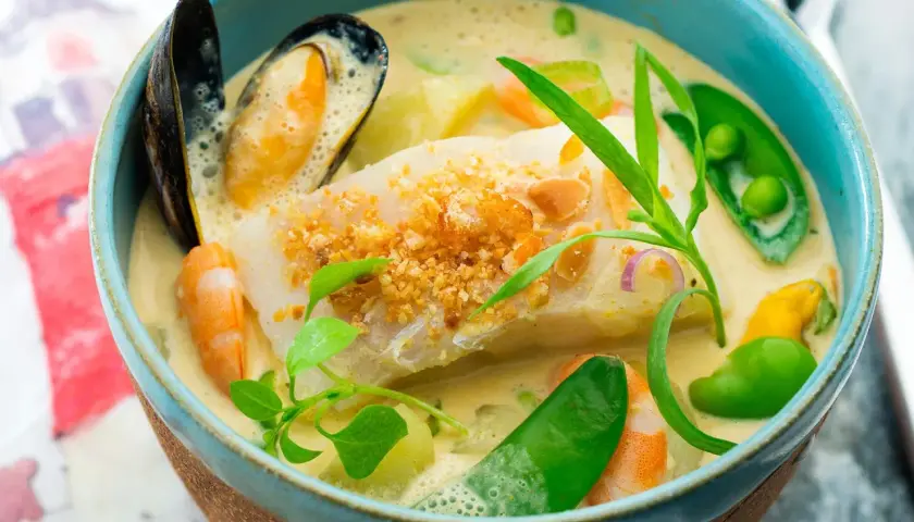 Une délicieuse marmite du pêcheur crémeuse avec poisson blanc, crevettes, moules, petits pois et herbes fraîches.