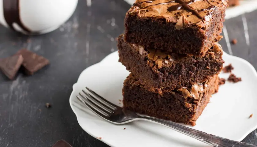 Pile de gâteaux au chocolat sur une assiette blanche avec une fourchette.