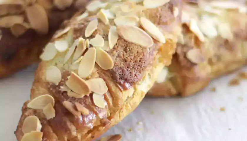 Croissants aux amandes dorés et croustillants, parsemés d'amandes effilées.