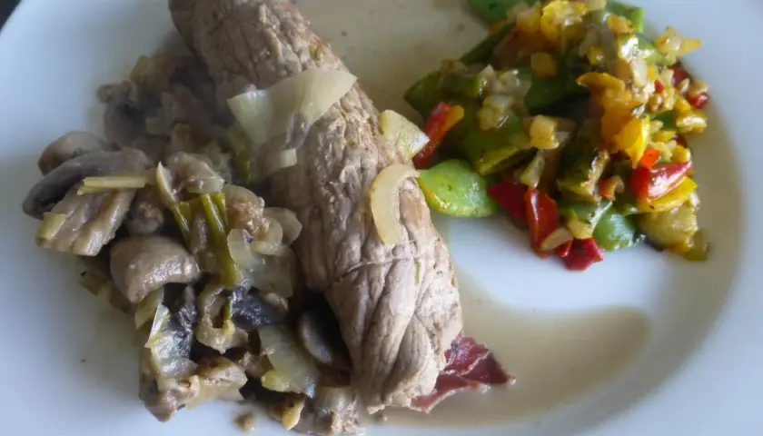 Un plat de bocconcini de veau tendre, servi avec des champignons sautés et des poivrons colorés. Un délice !