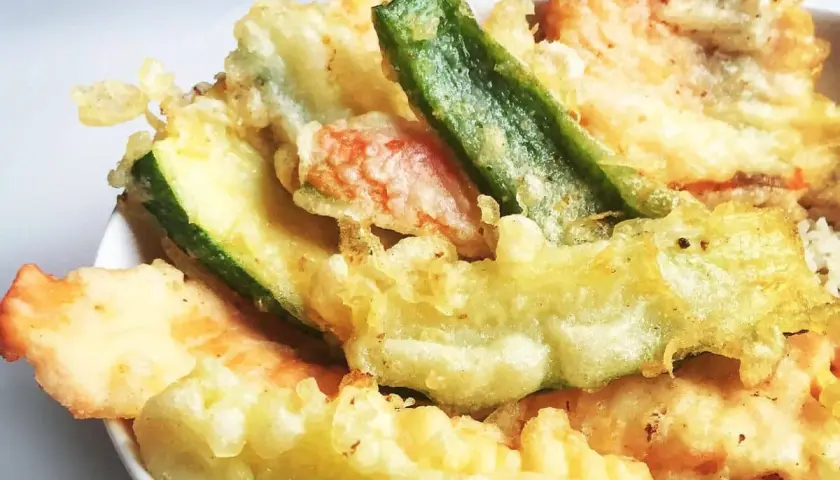 Un assortiment coloré de tempura de légumes, avec des courgettes, des haricots verts et d'autres délices croustillants.