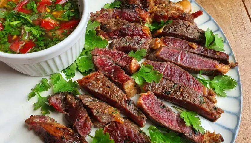 Tranches de bœuf grillé, juteuses et saignantes, servies avec une sauce tomate et coriandre. Un plat qui ferait presque pleurer de joie un tigre gourmand.