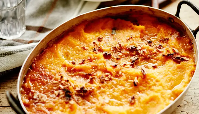 Hachis Parmentier gratiné, doré et parsemé de noix dans un plat ovale.