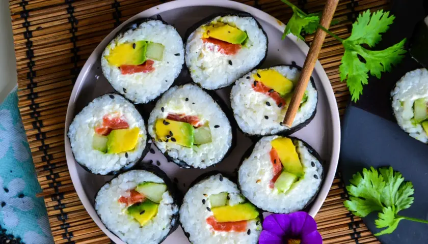 Assiette de makis frais, remplis d'avocat, concombre et saumon. Une belle recette sushi pour un repas léger.